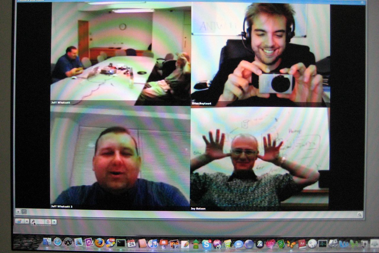 A video call with four participants; one takes a photo, another makes a playful gesture, and others engage.