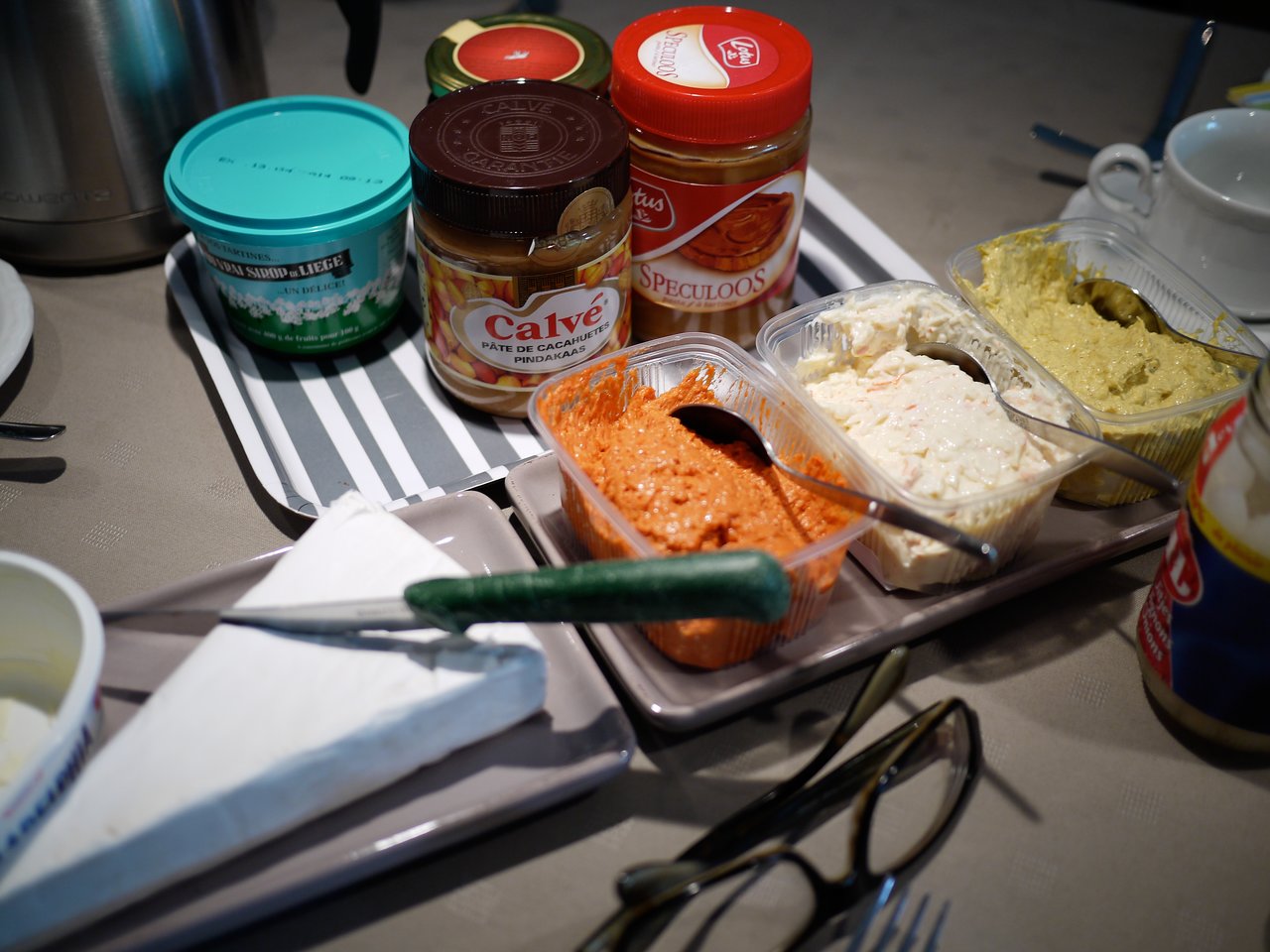 An assortment of spreads, cheese, and condiments on a table, ready for lunch.