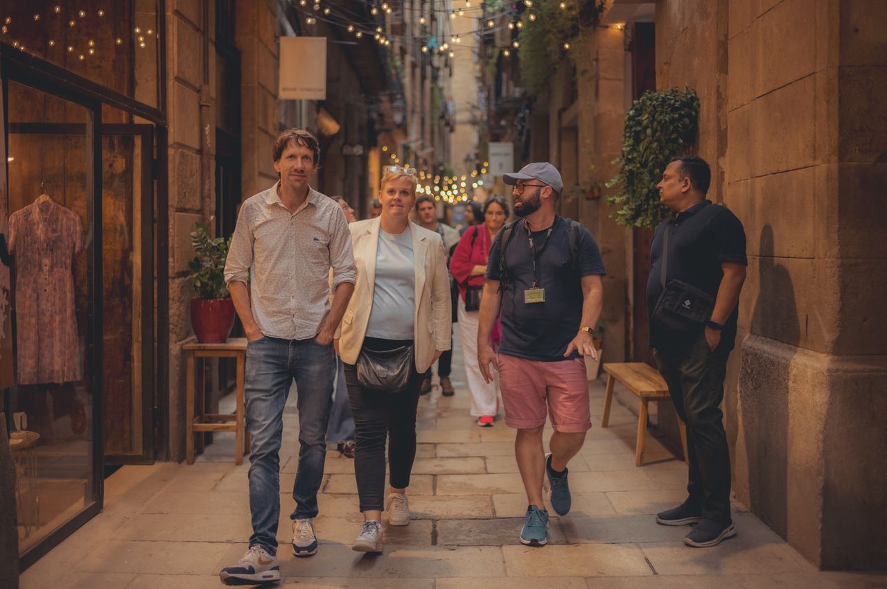 A group of people walking down a narrow street in the El Born district of Barcelona.