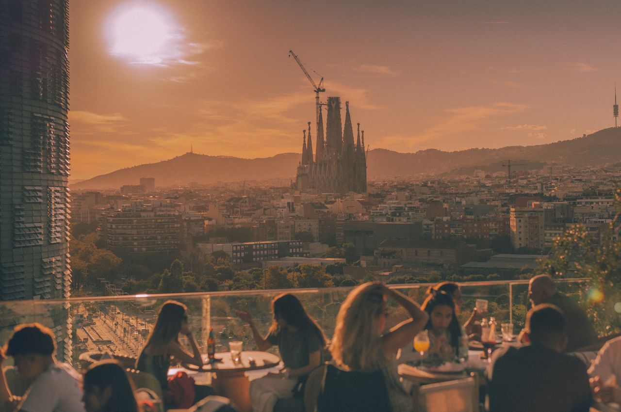 Barcelona rooftop view with La Sagrada Familia in the distance and Torre Agbar to the left.