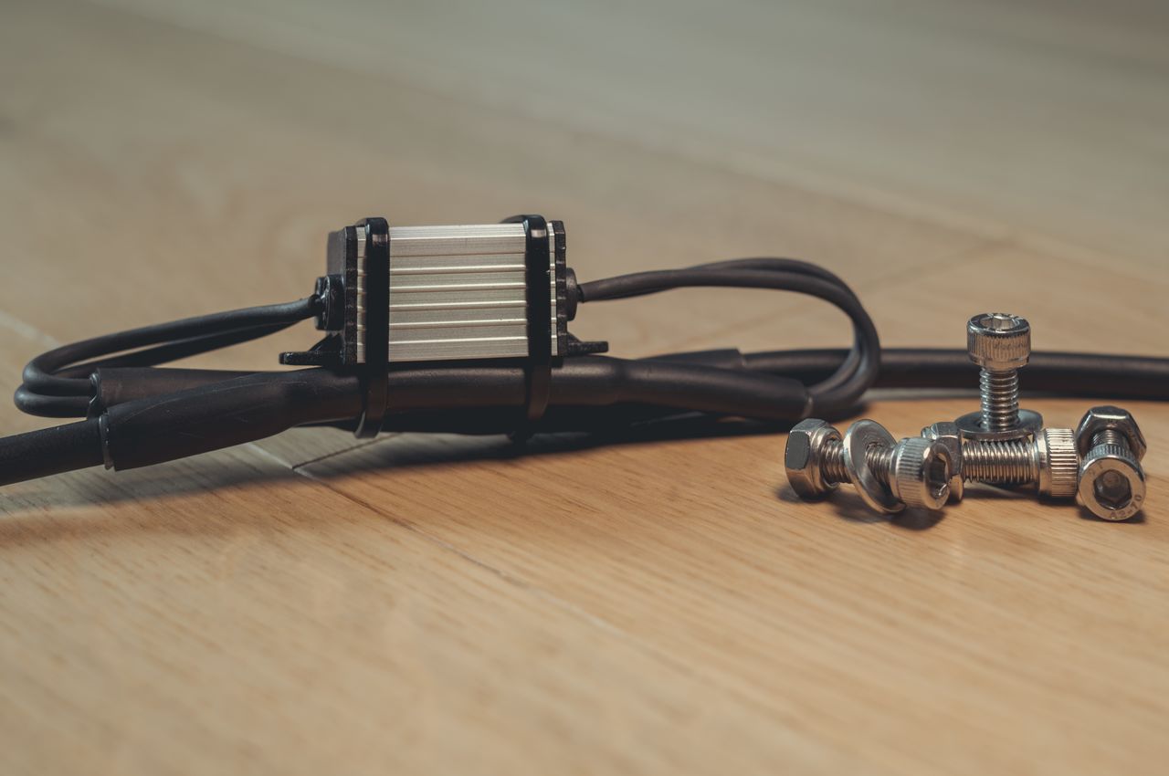 A 12V to 5V voltage converter in a waterproof metal box the size of a matchbox, integrated into a cable with heat shrink tubing.
