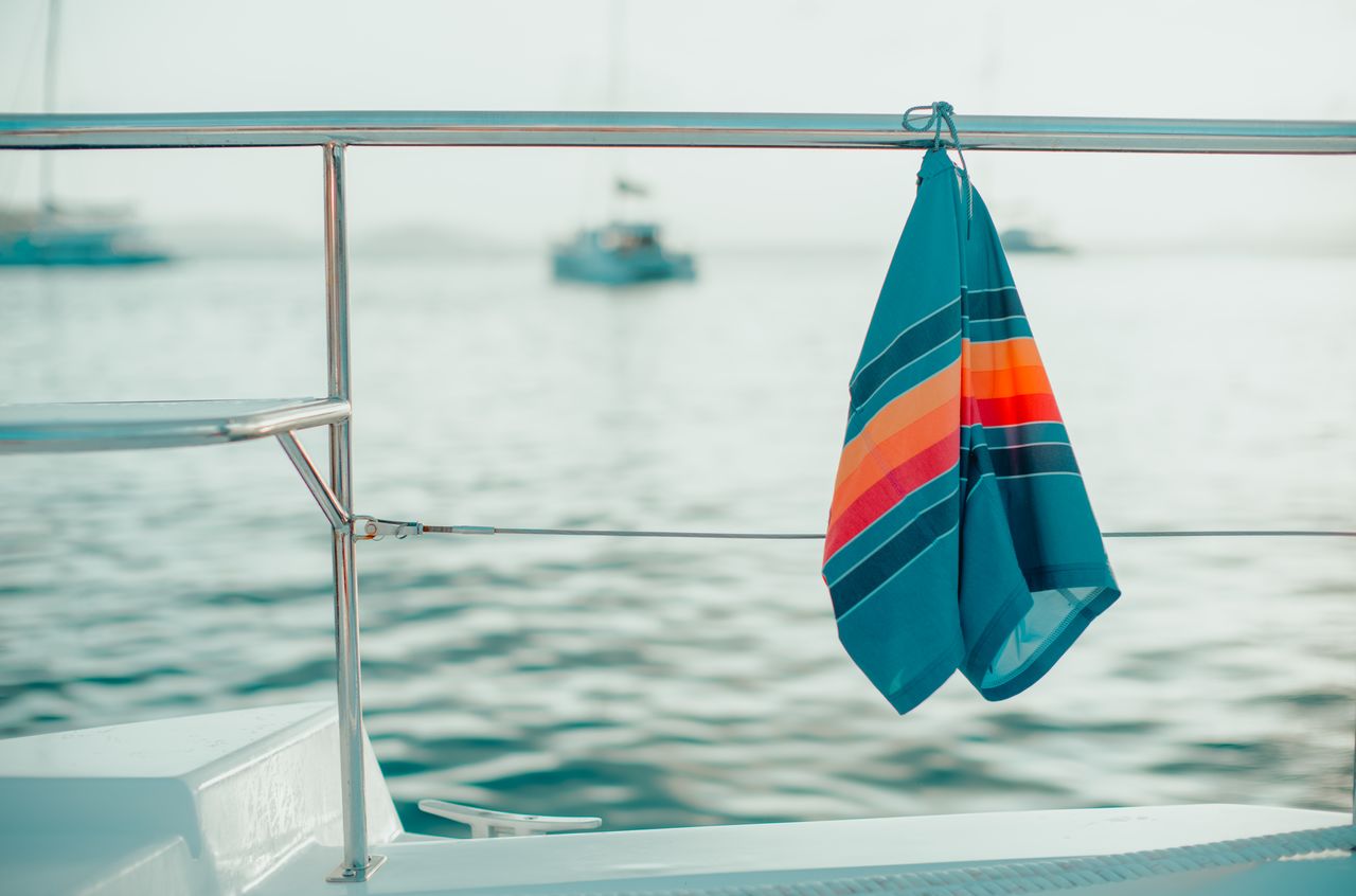 Swim shorts drying on the railing of a boat