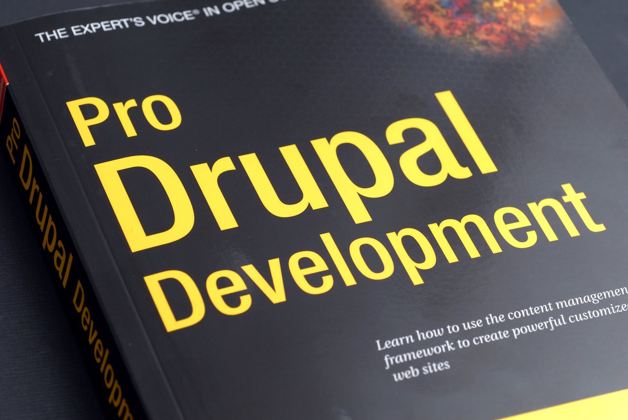 Close-up of the book cover "Pro Drupal Development" with bold yellow text on a black background.