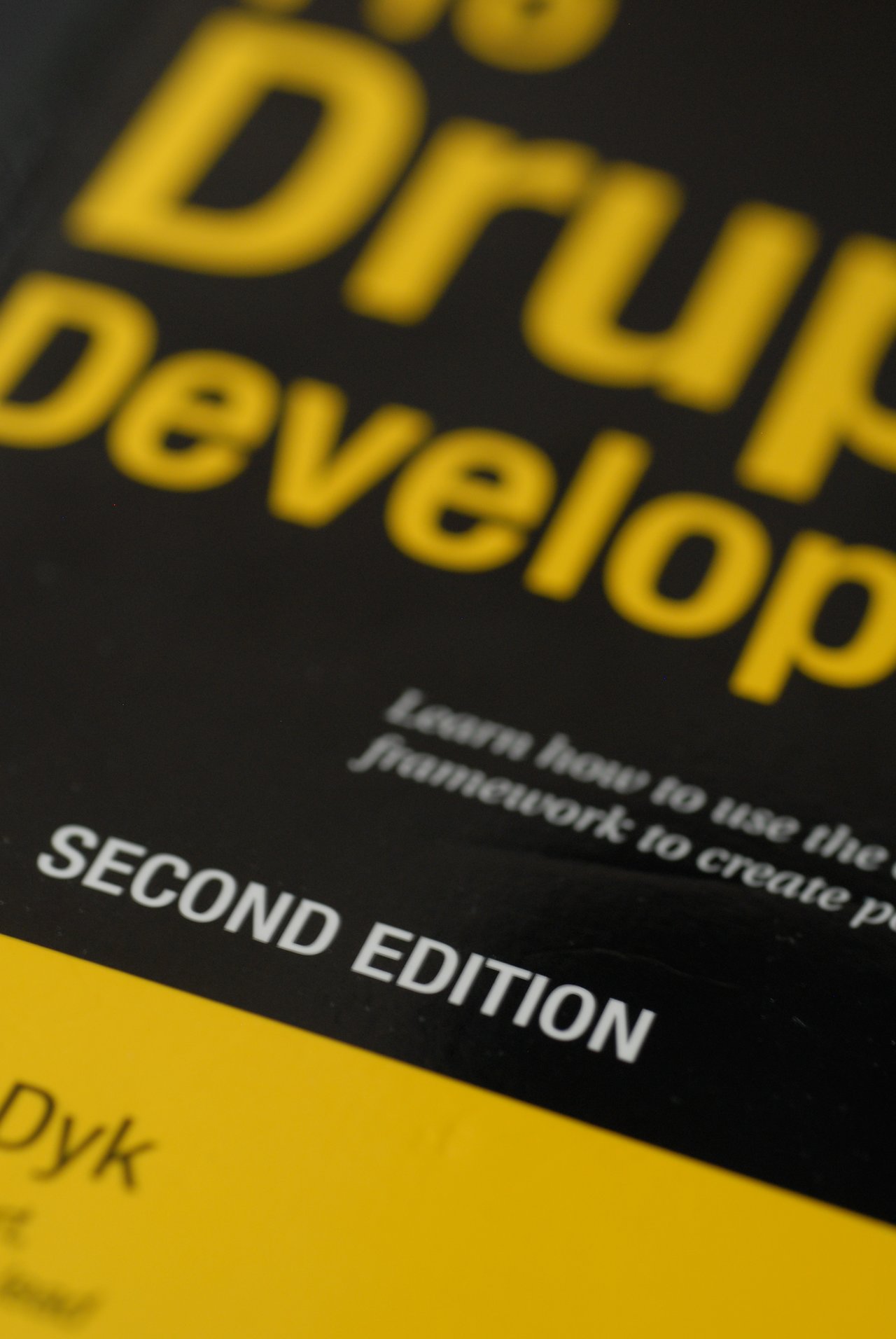 Close-up of a book cover titled "Pro Drupal Development, Second Edition", with bold yellow and white text.