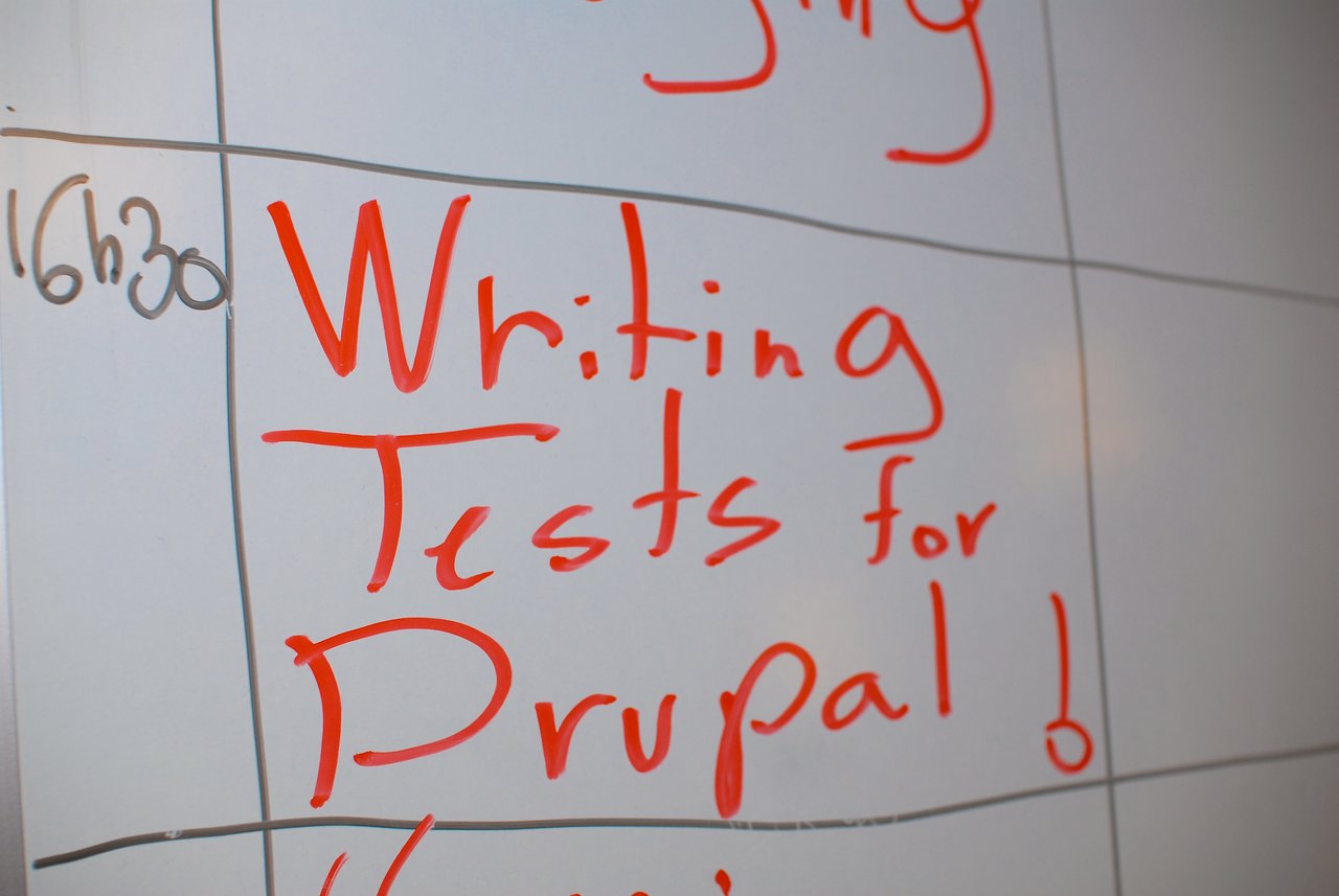 A whiteboard displays "Writing Tests for Drupal!" in red marker, scheduled for 16:30 at DrupalCamp Paris 2008.