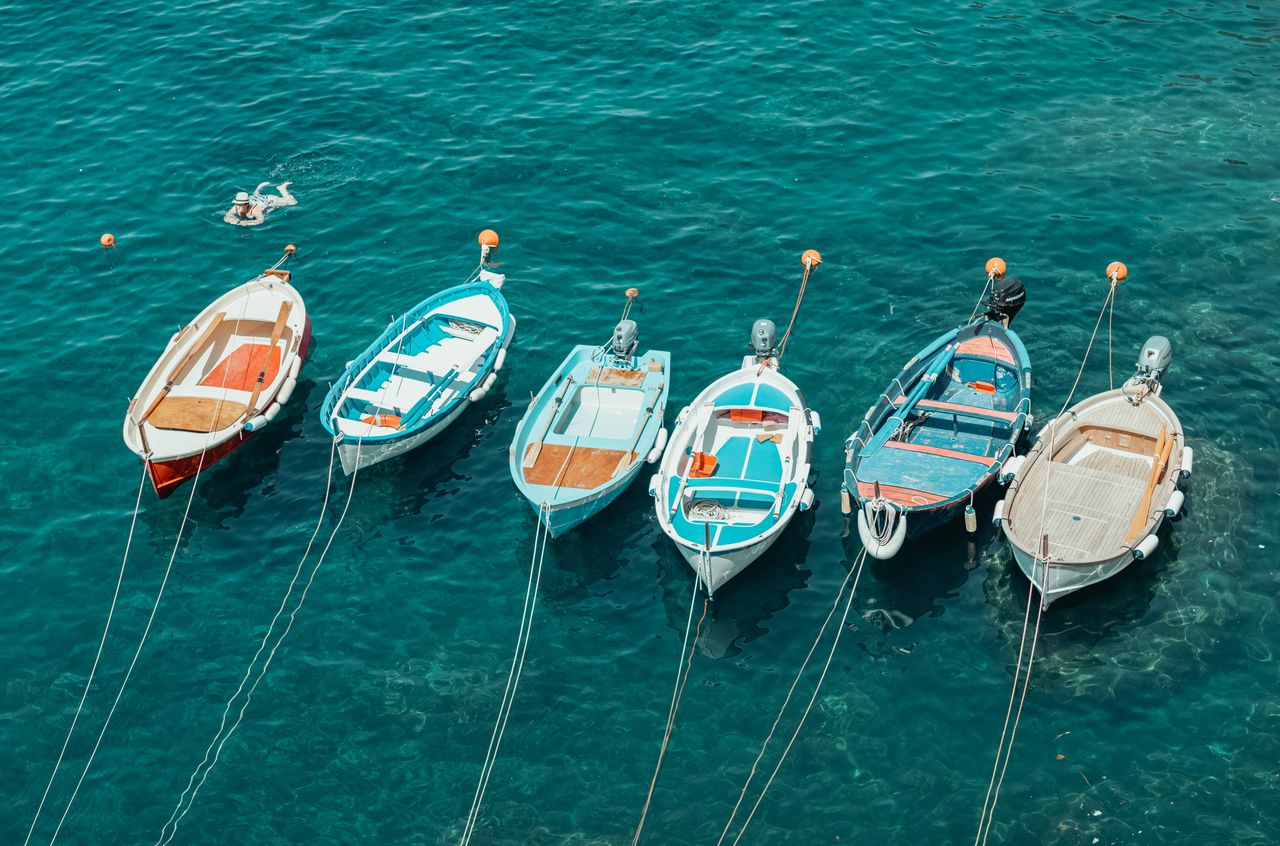 Five small, wooden fishing boats next to each other.