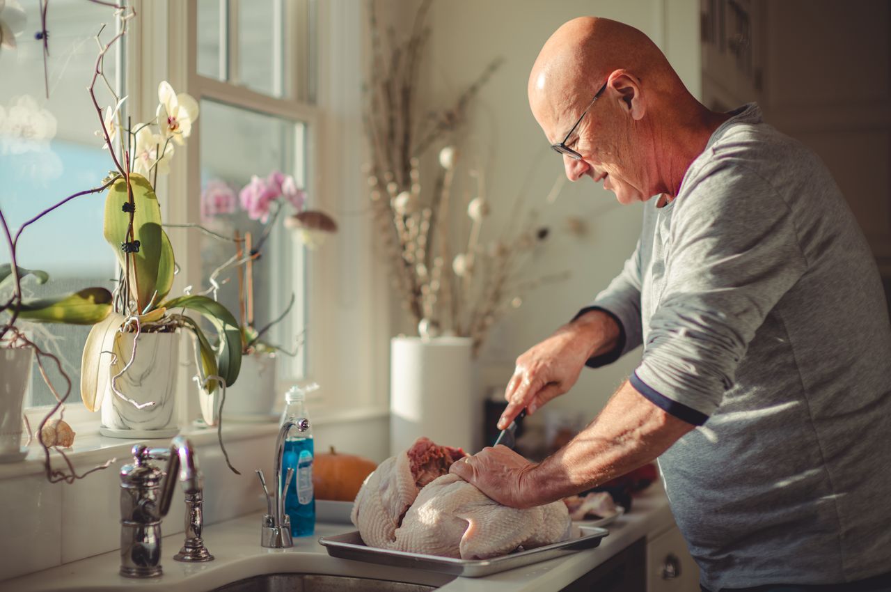 Jay expertly uses a sharp knife to debone a turkey, carefully removing the backbone to prepare it for roasting.