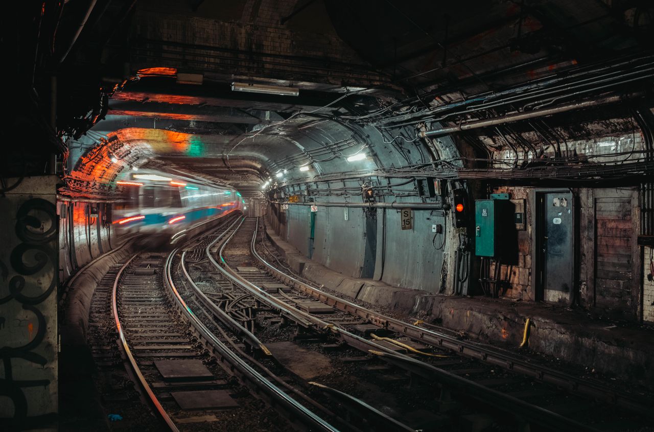 A underground subway tunnel with an incoming train.