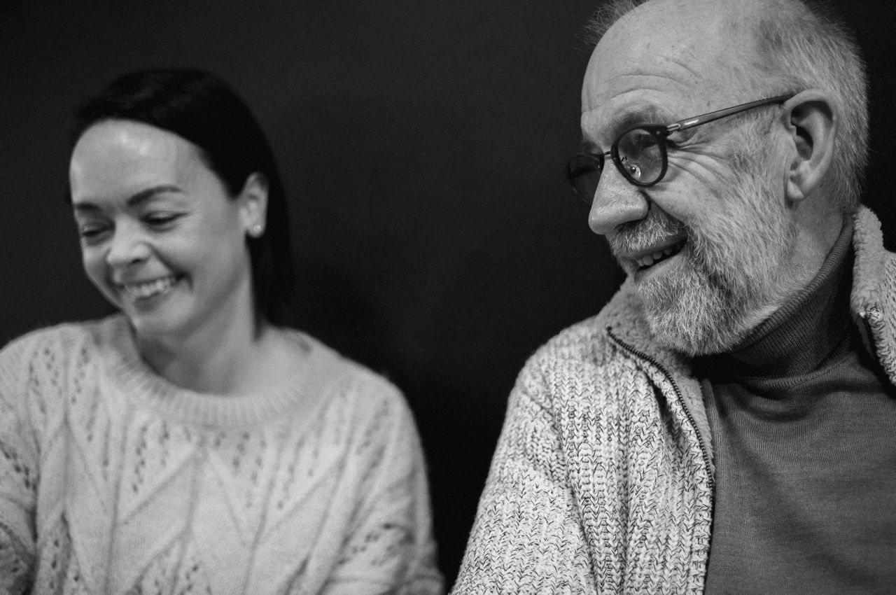 A black and white portrait of two individuals sharing a moment of laughter.