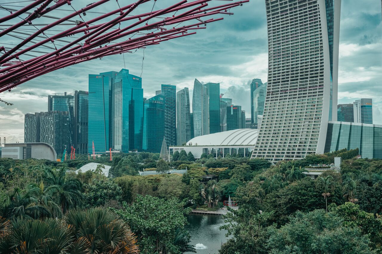 Singapore skyline with lush greenery in the foreground.