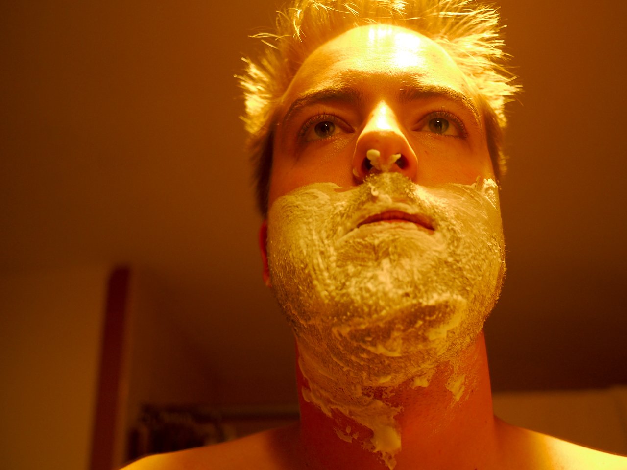 A person with shaving cream on their face, preparing to shave for the start of Movember.