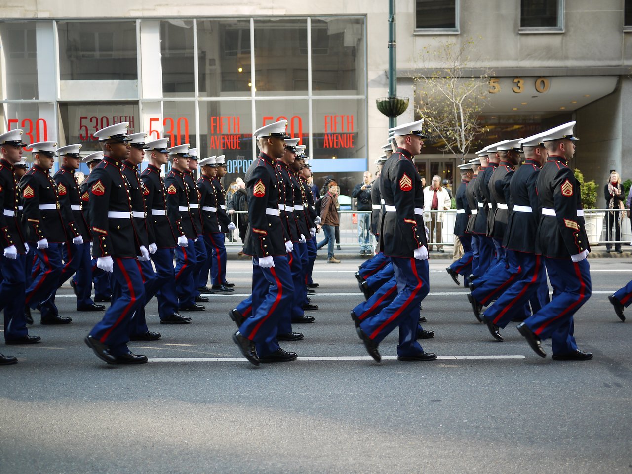 Marines in dress blues marching in step past 530 Fifth Avenue.