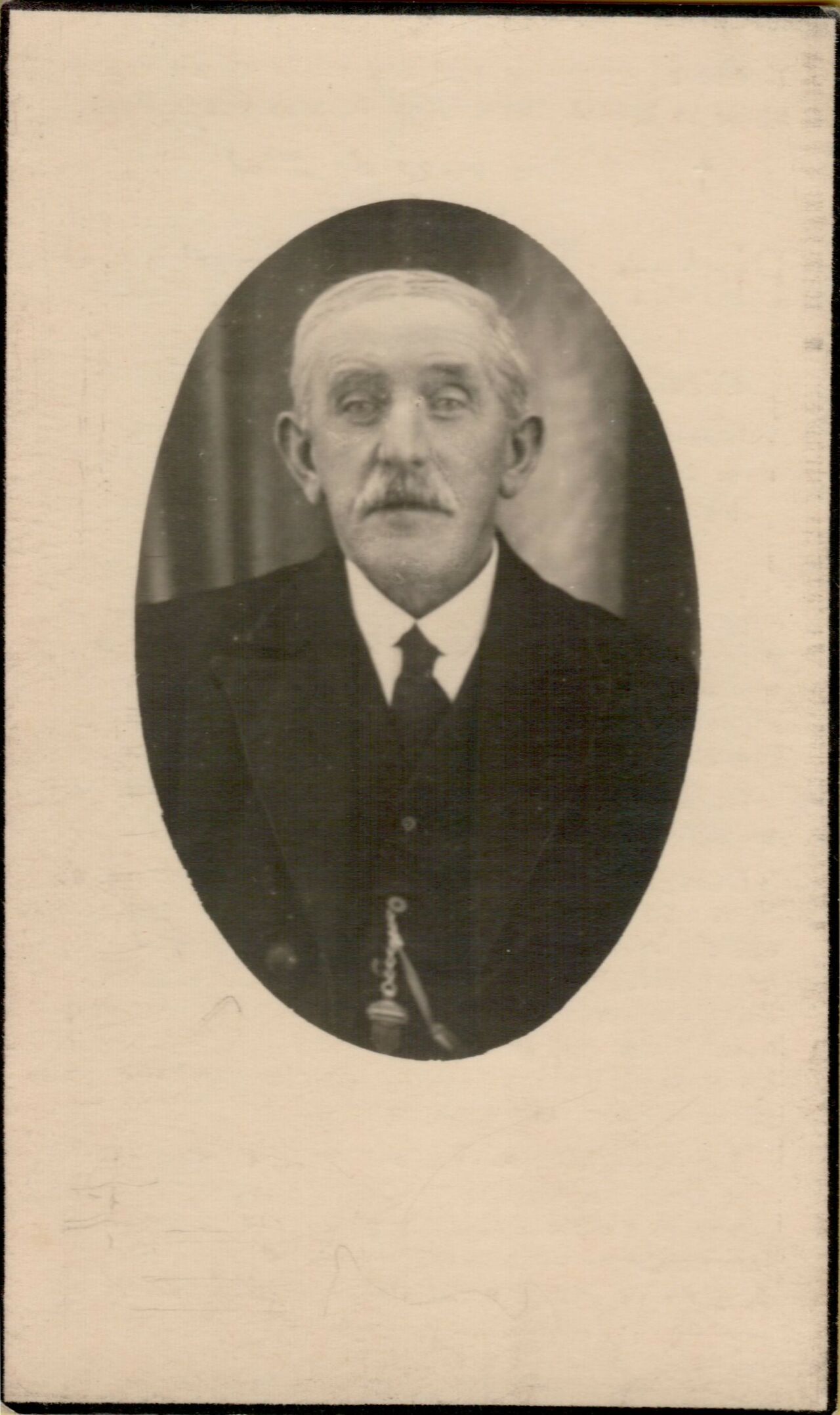 Black and white memorial card featuring a portrait of an older man in a suit with a pocket watch chain.