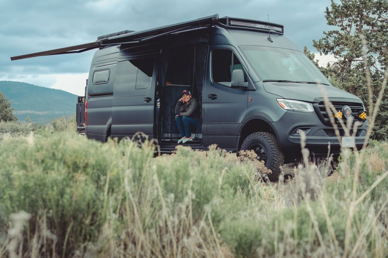 Skull Hollow Campground Person sitting in the doorway of a parked camper van at a quiet, remote campground.