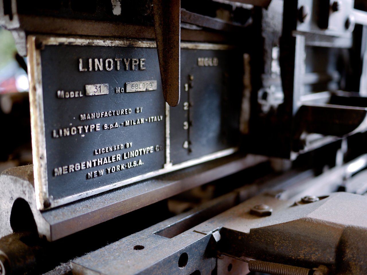 Close-up of a Linotype machine nameplate, showing model and manufacturing details on the metal surface.