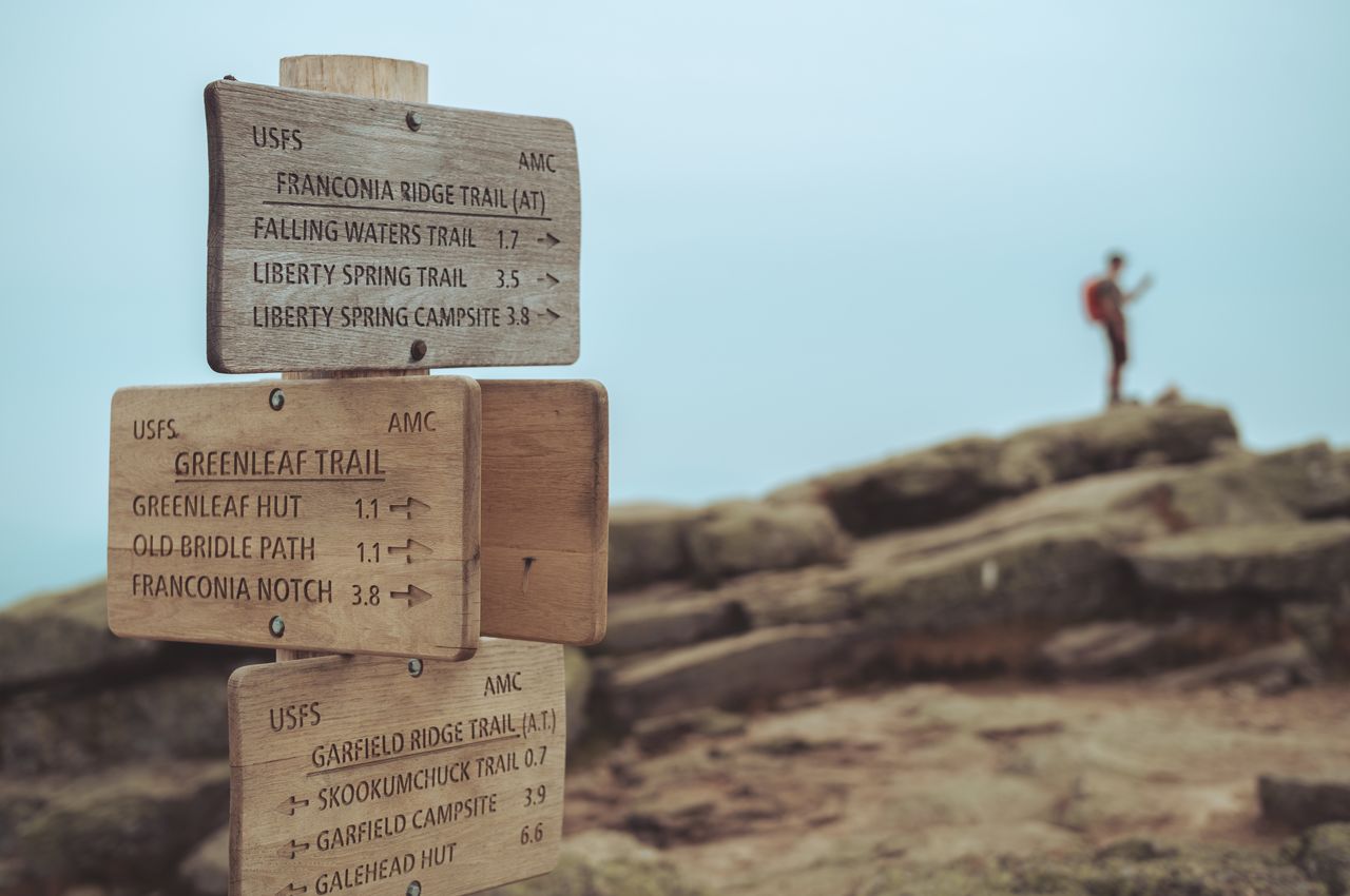 At the summit of Mount Lafayette A wooden signpost indicating various trail directions.