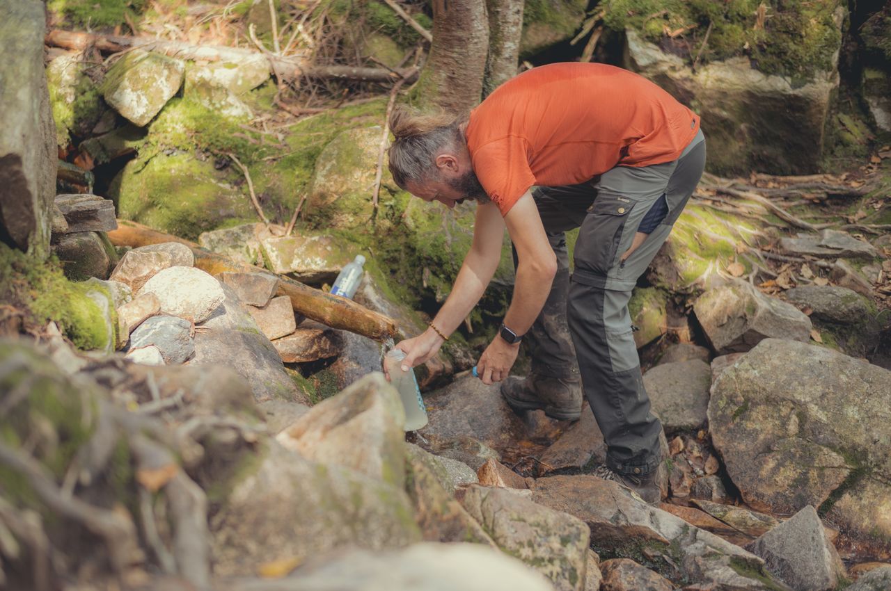 Refilling water on Garfield Ridge Trail A hiker filling a water bottle from a small stream.
