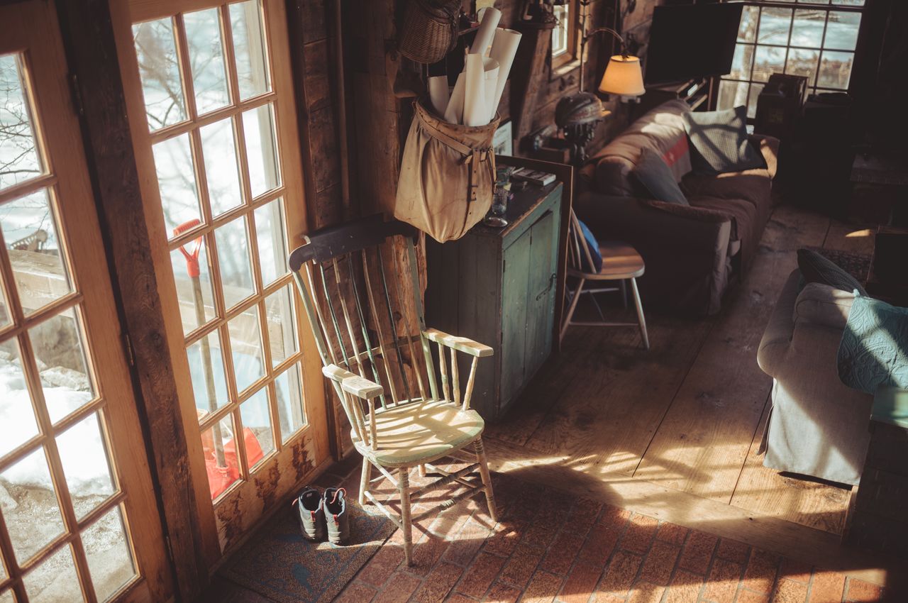Sun rays stream through the window of an old barn, casting a pattern of light on the floor.