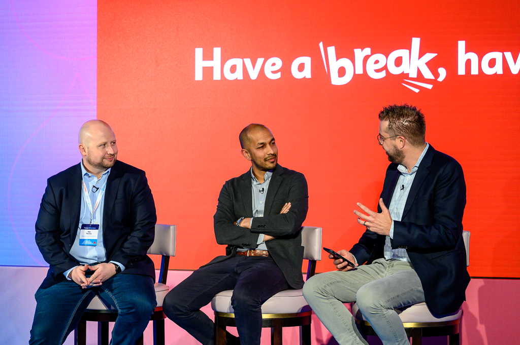 Three people engaged in a discussion on stage.