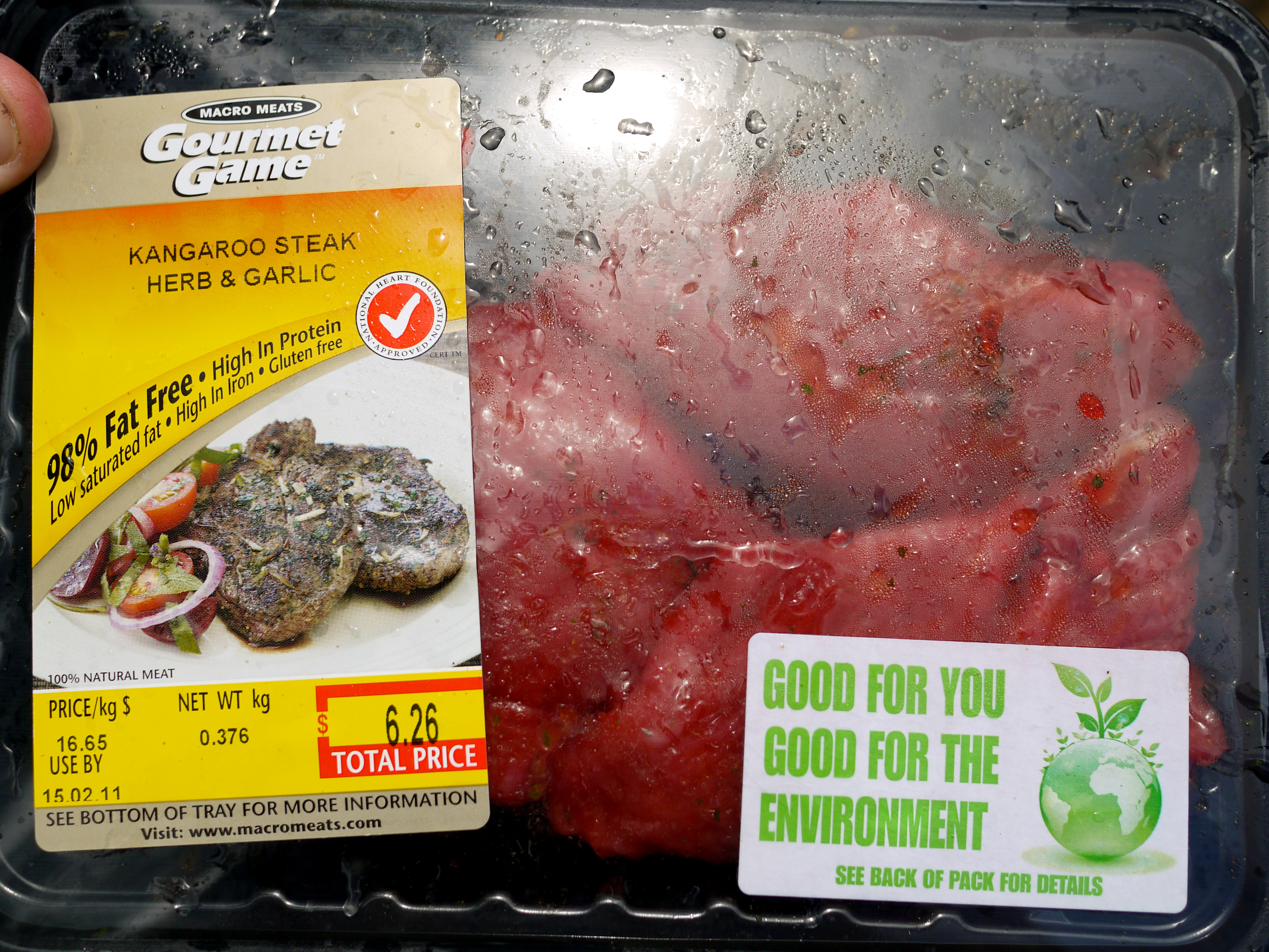 Packaged kangaroo steak with herb and garlic seasoning, labeled as high in protein and environmentally friendly.