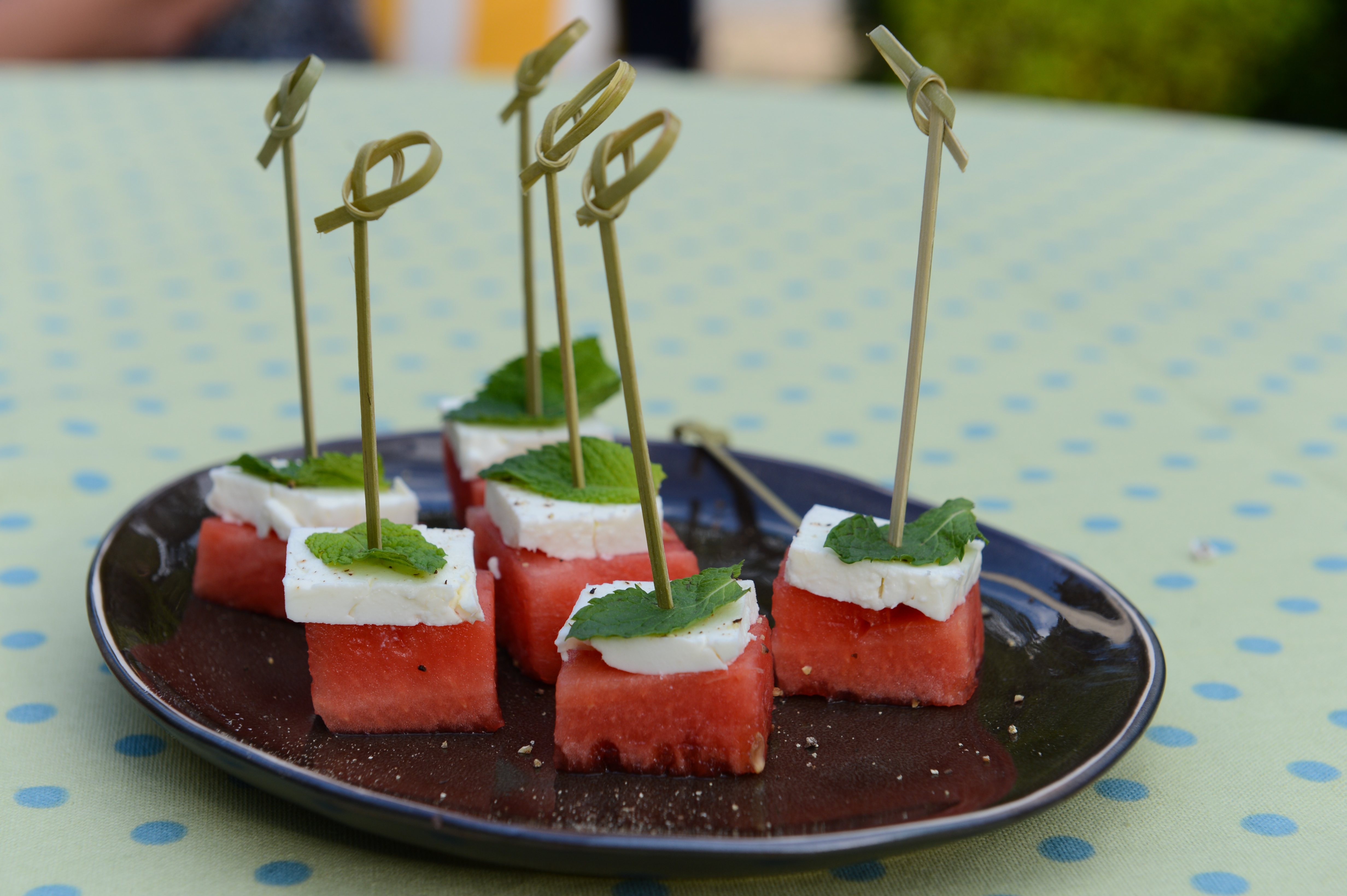 A plate of watermelon, feta, and mint skewers on a table during a cooking class.