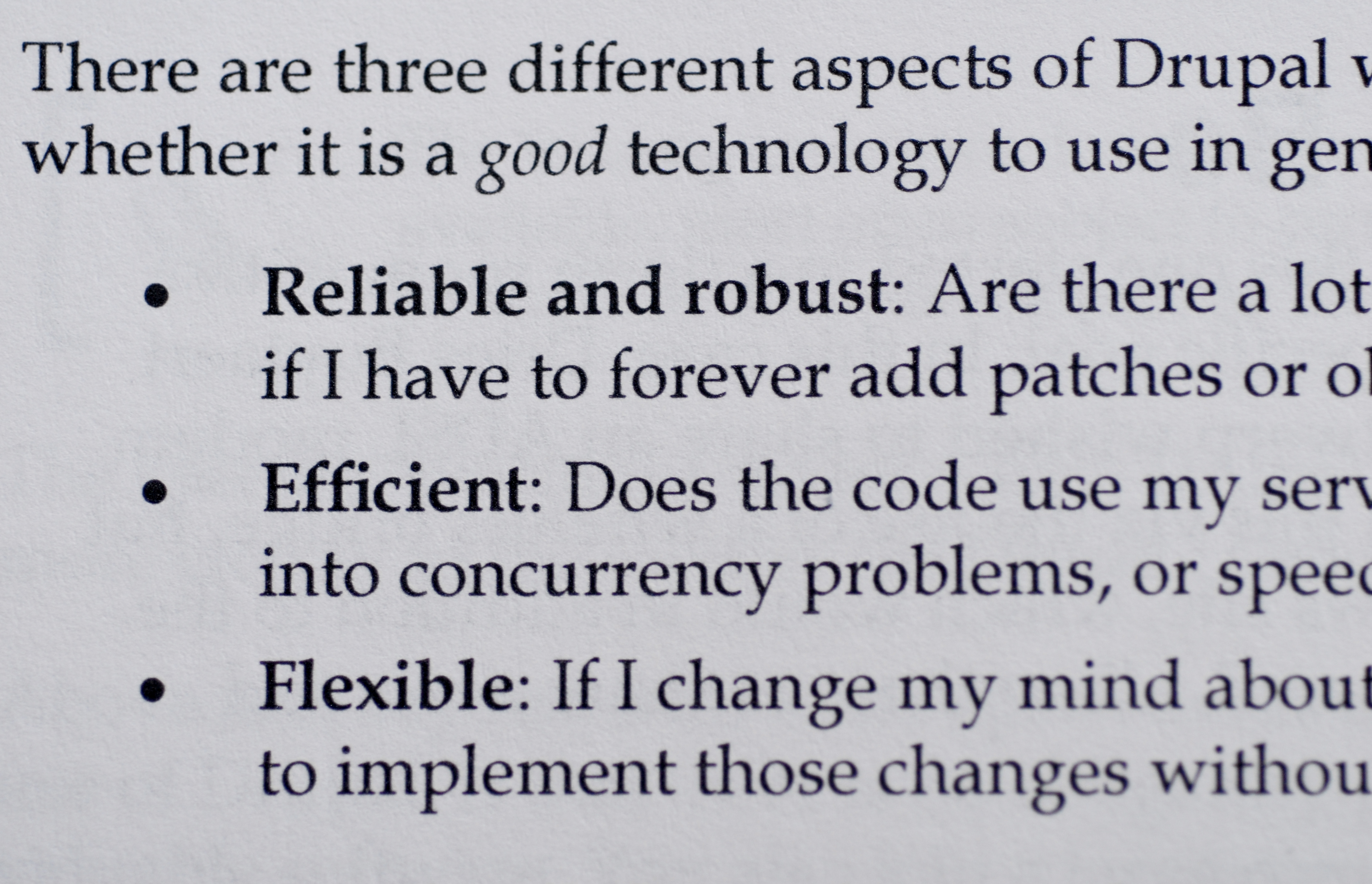 A book page discussing three key aspects of Drupal: reliability, efficiency, and flexibility in software development.
