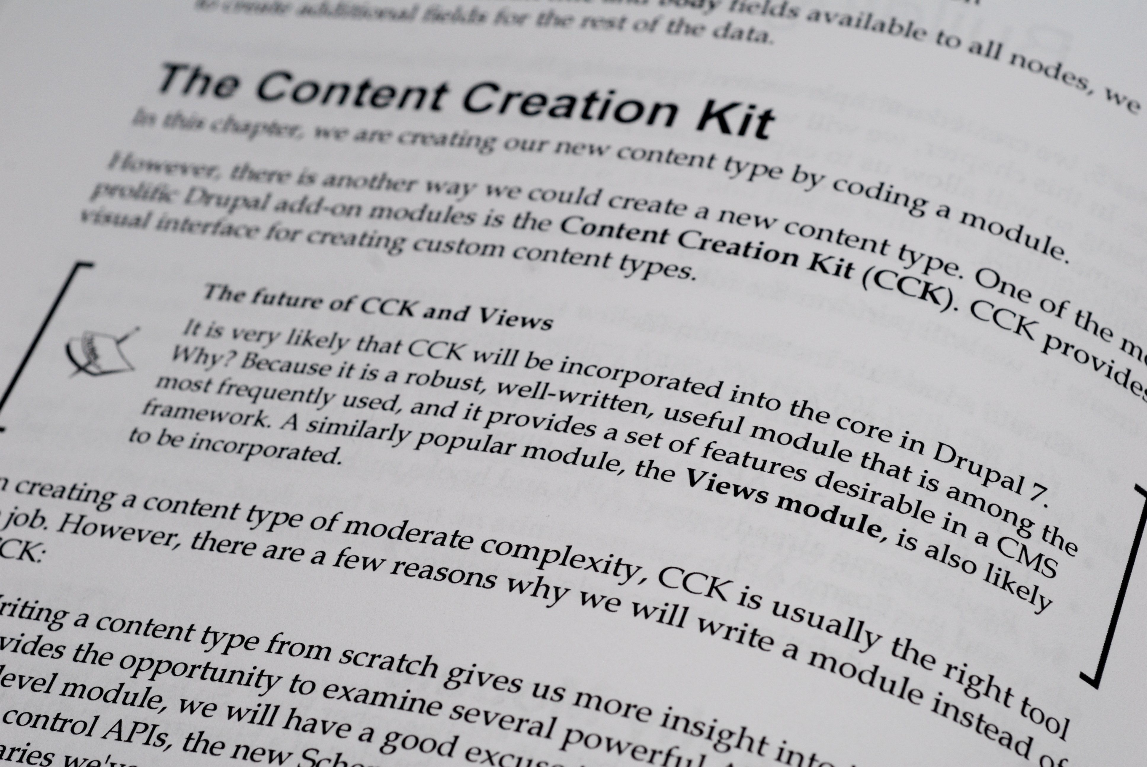 Close-up of a book page discussing the Content Creation Kit (CCK) and Views module in Drupal development.