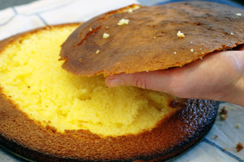 A hand taking the top of the cake off