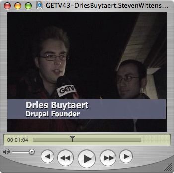 A person holds a GETV microphone, interviewing another person.