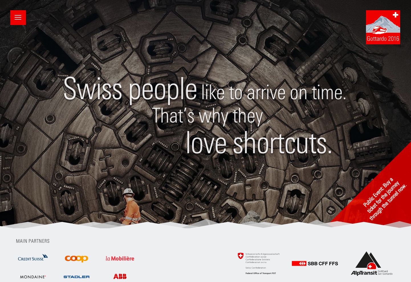 A worker in an orange uniform stands in front of a large tunnel boring machine with Swiss tunnel promotion text.