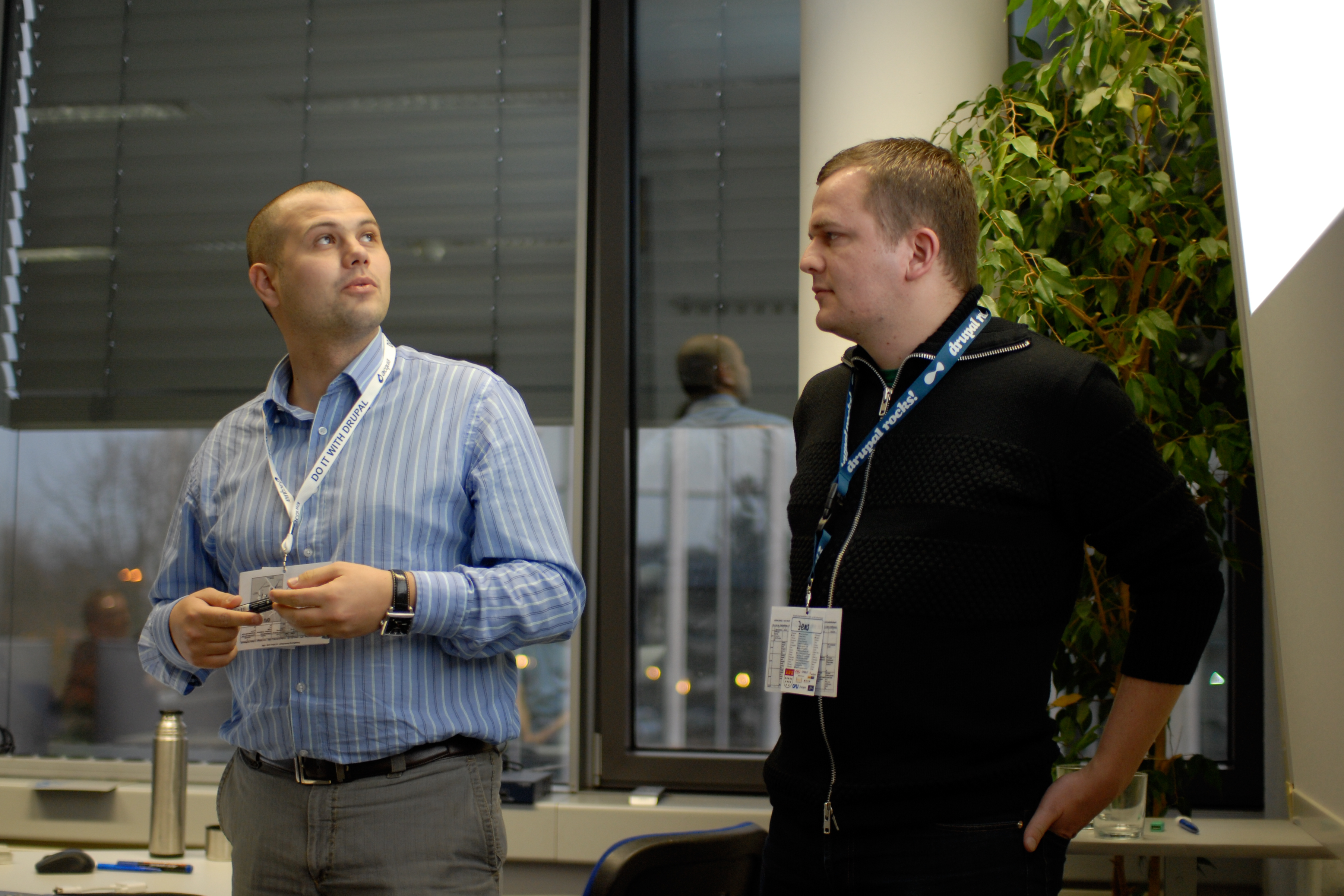 Two presenters from Propeople stand in front of a screen, discussing their work at DrupalCamp Cologne 2009.