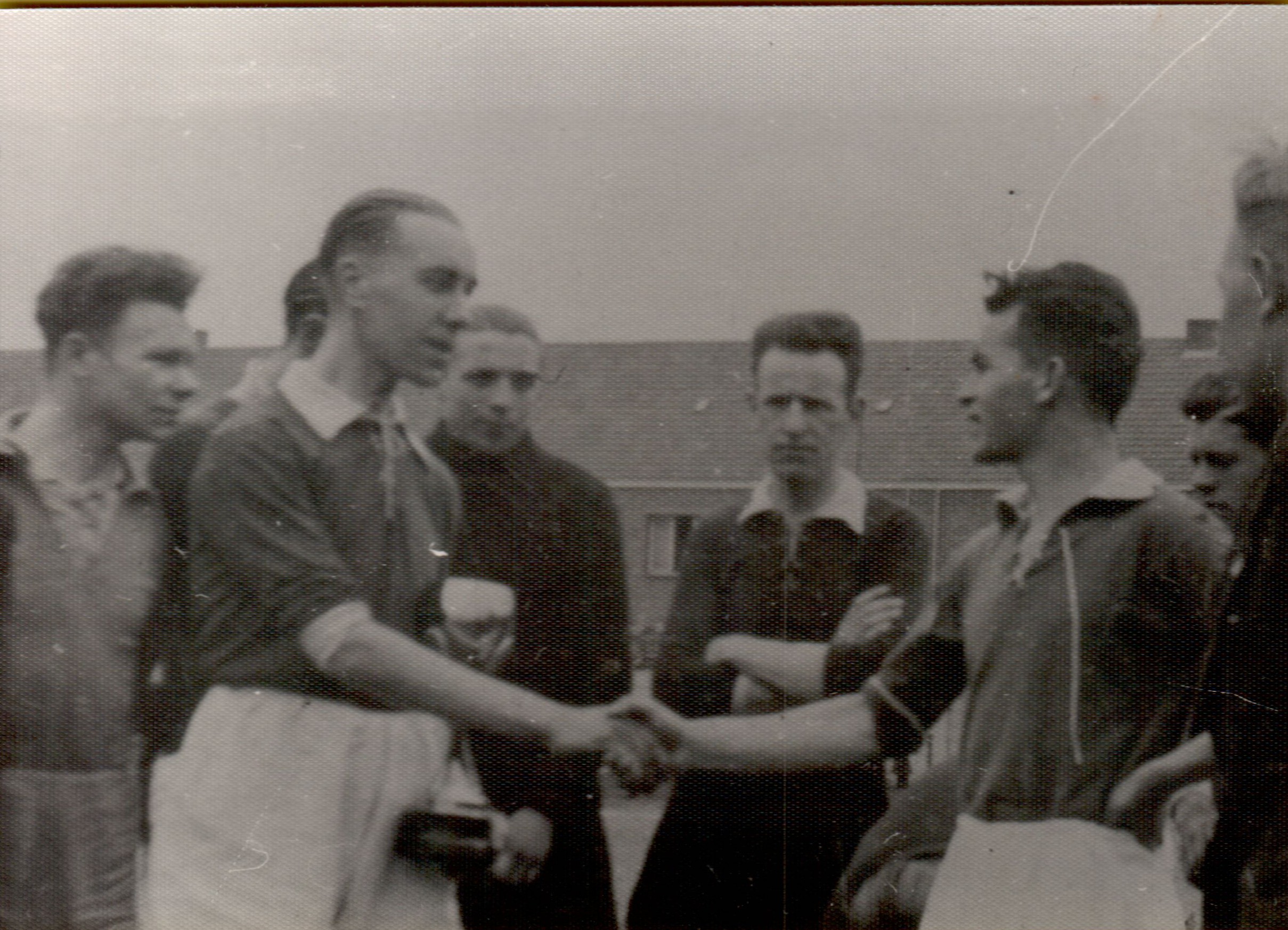 Two soccer captains shake hands on the field before a match, surrounded by teammates and officials.